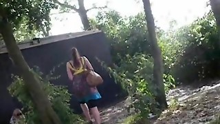 Fellow with a camera filming beautiful nymphs in a park