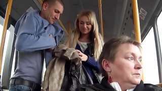 A platinum-blonde is getting torn up stiff in the bus while people are looking