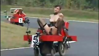 Dolls racing around a track while faux-cock plumbed