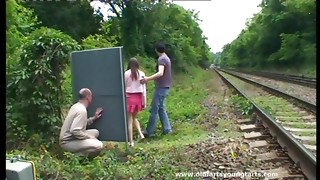 A boy strokes off while eyeing a duo smashing outdoors